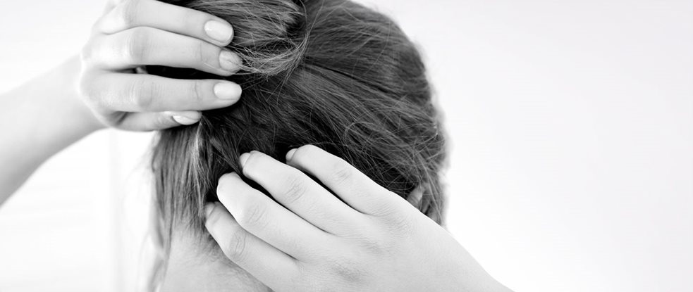 A woman scratching her itchy scalp