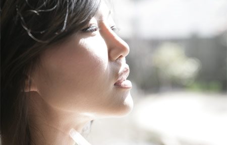 امرأة آسيوية تنظر إلى الشمس 