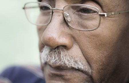 رجل مسن داكن البشرة و ذو ثنيات أنفية شفوية واضحة