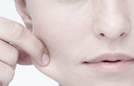 امرأة شابة تجذب خدها الأيمن