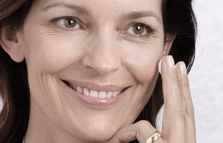 امرأة تضع كريم على وجهها. 