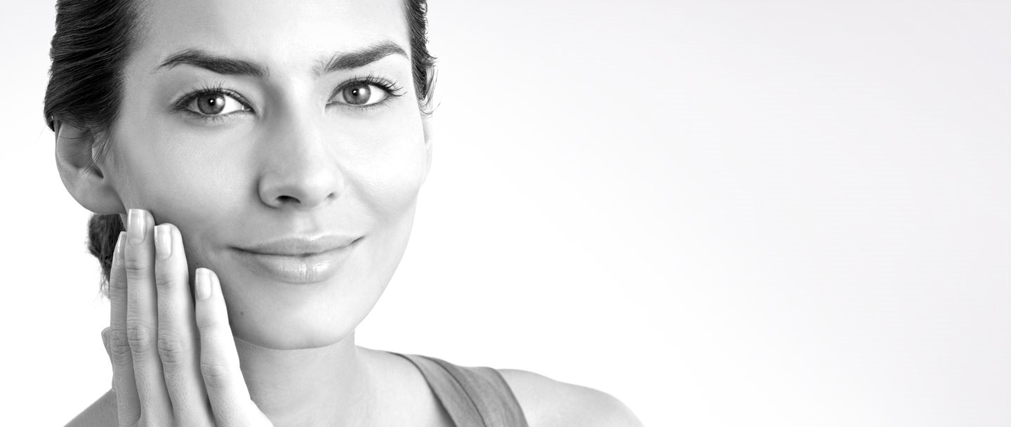 امرأة في منتصف العمر تلمس خدها الأيمن بيدها