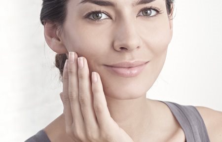 املرأة تضع كريماً على وجهها